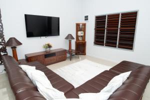 a living room with a couch and a flat screen tv at Sikeci Villa in Pacific Harbour