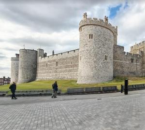 zwei Personen stehen vor einem Schloss in der Unterkunft Value Stay Comfortable Rooms Windsor Legoland Heathrow in Windsor