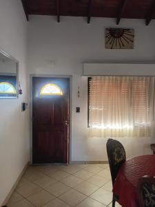 een eetkamer met een deur en een tafel en stoelen bij Casa Monte Hermoso del Este in Monte Hermoso