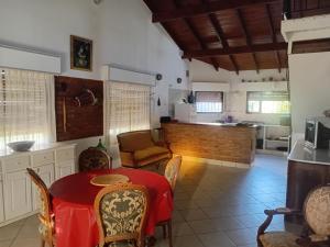 een keuken en eetkamer met een rode tafel en stoelen bij Casa Monte Hermoso del Este in Monte Hermoso