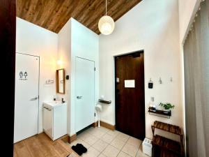 a hallway with a bathroom with a toilet and a door at Futtsu Pool Villa A&F -富津プールヴィラ A&F- in Futtsu