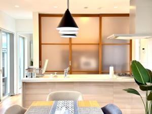 a kitchen with a table and a dining room at Futtsu Pool Villa A&F -富津プールヴィラ A&F- in Futtsu +19 photos
