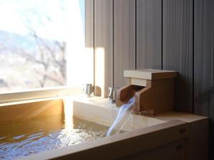 a water fountain in a room with a window at BLANC yatsugatake 2026年4月24日グランドオープン in Hokuto