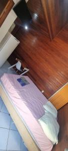 een bed in een kamer met een houten wand bij Pousada MALIBU BEACH in Florianópolis +12 foto's