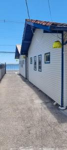 een wit gebouw met een blauw dak naast de oceaan bij Pousada MALIBU BEACH in Florianópolis