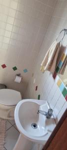 een badkamer met een wit toilet en een wastafel bij Pousada MALIBU BEACH in Florianópolis