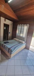 een bed in een kamer met een houten plafond bij Pousada MALIBU BEACH in Florianópolis
