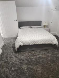 une chambre avec un lit et un mur blanc dans l'établissement Redlane, à Warmingham