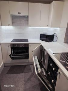 une cuisine avec une cuisinière et un micro-ondes dans l'établissement Redlane, à Warmingham