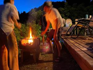 eine Gruppe von Menschen, die um ein Feuer stehen in der Unterkunft Tiny Camp House Kurage - Vacation STAY 66334v in Kamijinoo