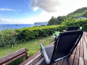 ein Schaukelstuhl auf einer Terrasse mit Blick auf den Ozean in der Unterkunft Tiny Camp House Kurage - Vacation STAY 66334v in Kamijinoo