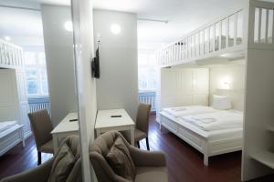 a room with a bed and a desk and chairs at Heimatgleis in Brilon-Wald
