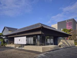 唐津ONCRI-Karatsu おんくり唐津的街道上一座黑色屋顶的建筑