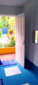 an open white door in a room with a window at SUITES E CHALES PRIVADOS Rock's&Rose's home in Camburi