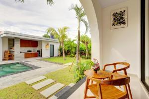 ein Wohnzimmer mit einem Tisch und Blick auf ein Haus in der Unterkunft Close to Beach Paddy View 6BR Villa with Billiard in Tanah Lot