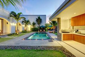 ein Swimmingpool im Hinterhof eines Hauses in der Unterkunft Close to Beach Paddy View 6BR Villa with Billiard in Tanah Lot