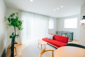 a living room with a red couch and a table at 藤乃宿 ペットと暮らすように泊まる宿 in Sapporo +85 photos
