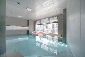 a swimming pool in a building with a large window at The Moor in Busan