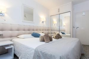 1 dormitorio con 1 cama blanca grande y espejo en Du Soleil Apart, en Sitges