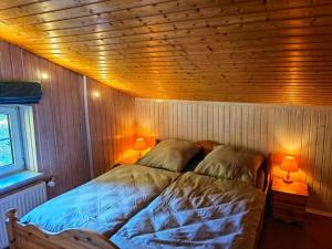 een slaapkamer met een bed in een houten kamer bij Farmhouse for arrival in Lütjenwestedt