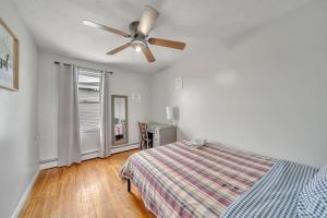 伍斯特Cozy One Bedroom Suite的一间卧室，里面有一张床和一个吊扇 更多23张照片