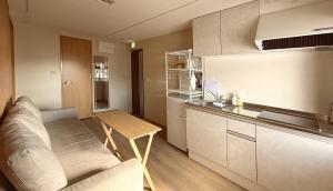 una cucina con un divano e un tavolo in una stanza di 涼亭 川 Ryoutei Kawa a Hakuba Altre 38 foto