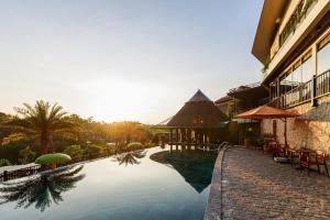 een zwembad in een resort met tafels en stoelen bij Valley De Mango Hue in Thôn Châu Chữ
