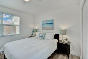 a white bedroom with a bed and a window at Beach Escape One Block from the Beach in Pompano Beach