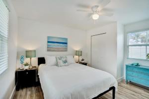 a white bedroom with a bed and a blue dresser at Beach Escape One Block from the Beach in Pompano Beach
