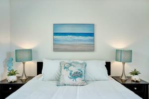 a bedroom with a white bed with two lamps at Beach Escape One Block from the Beach in Pompano Beach +28 photos