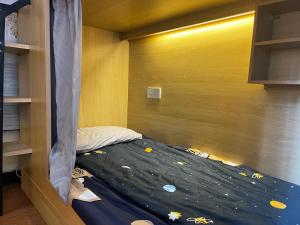 ein kleines Schlafzimmer mit einem Bett in einem Zimmer mit in der Unterkunft Notting Hill Hostel in Bao'an