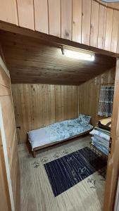 een bed in een kamer met een houten wand bij Villa 155 in Popova Shapka