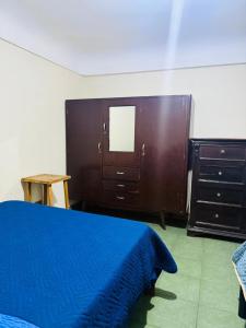 een slaapkamer met een bed, een ladekast en een spiegel bij Terraza 419 in Tarija