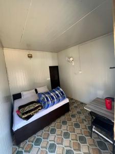 a bedroom with a bed in a small room at Yashraj Cottages in Jari