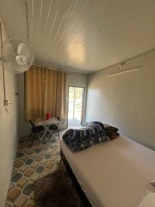 a bedroom with a bed in a room with a table at Yashraj Cottages in Jari