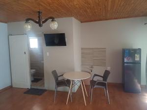 a dining room with a table and chairs and a refrigerator at Blackwood Guesthouse in Vereeniging