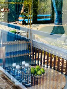 a shelf with bottles of water and a bowl of limes at Homestay xóm nhỏ in Ninh Hải
