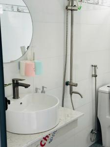 a bathroom with a white sink and a mirror at Homestay xóm nhỏ in Ninh Hải