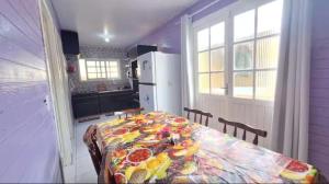 a kitchen with a table and a kitchen with a refrigerator at Casa com jacuzzi in Florianópolis