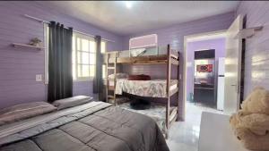 a bedroom with a bed and bunk beds in it at Casa com jacuzzi in Florianópolis