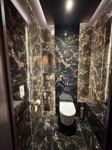 a black marble bathroom with a toilet and a shower at L'Écrin Beige - Immersive suite with private Jacuzzi in Champlan