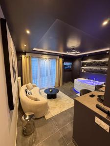 a living room with a couch and a tub at L'Écrin Beige - Immersive suite with private Jacuzzi in Champlan +10 photos