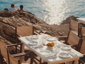 a white table with glasses and a bowl of fruit on it at Hyde Perth in Perth