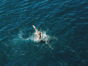 a person swimming in the water in the ocean at Hyde Perth in Perth