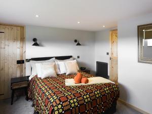 een slaapkamer met een bed met kussens erop bij Cowlas in Aberhosan