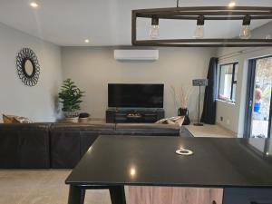 a living room with a couch and a tv at Crane's Nest - Luxury Ground in Pretoria