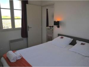 ein Schlafzimmer mit einem weißen Bett und zwei weißen Handtüchern in der Unterkunft Maison avec Terrasse, 2 Chambres, 4 Pers. - API-1-52-1368 in Carla-Bayle + 19 Fotos