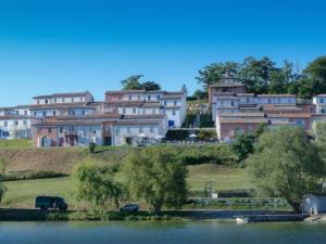 eine Gruppe von Häusern auf einem Hügel neben einem See in der Unterkunft Maison avec Terrasse, 2 Chambres, 4 Pers. - API-1-52-1368 in Carla-Bayle