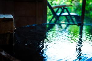 un tavolo in legno con acqua in cima di Saigakukan a Yufu