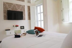 a bedroom with a bed with a laptop on it at Chez Mimosa Boutique - New address 135 Tran Hung Dao in Ho Chi Minh City
